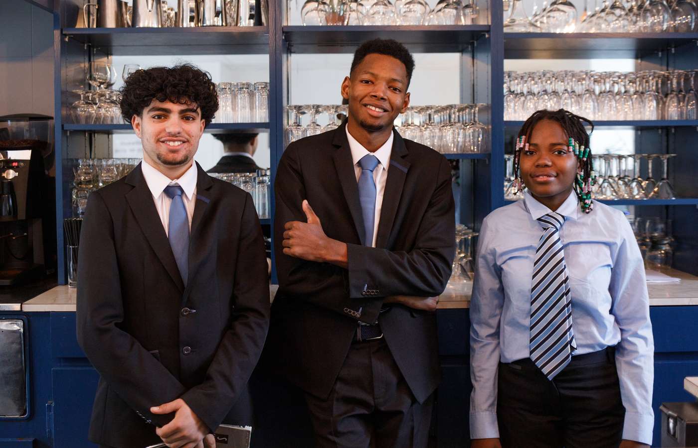 3 élèves devant le bar du restaurant